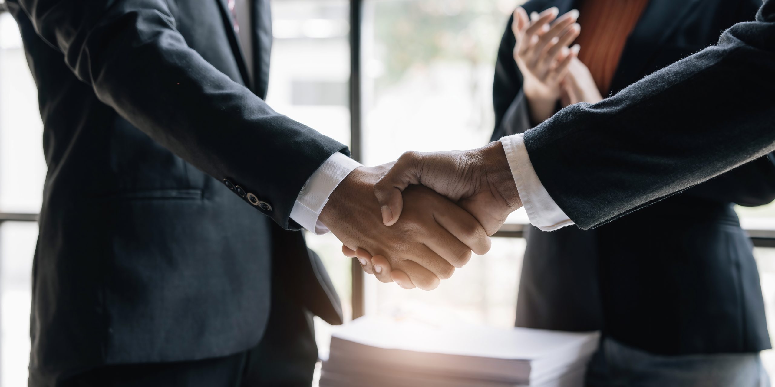 Poignée de main entre deux professionnels, illustration de la relation de confiance avec Fiducia Management à Luxembourg