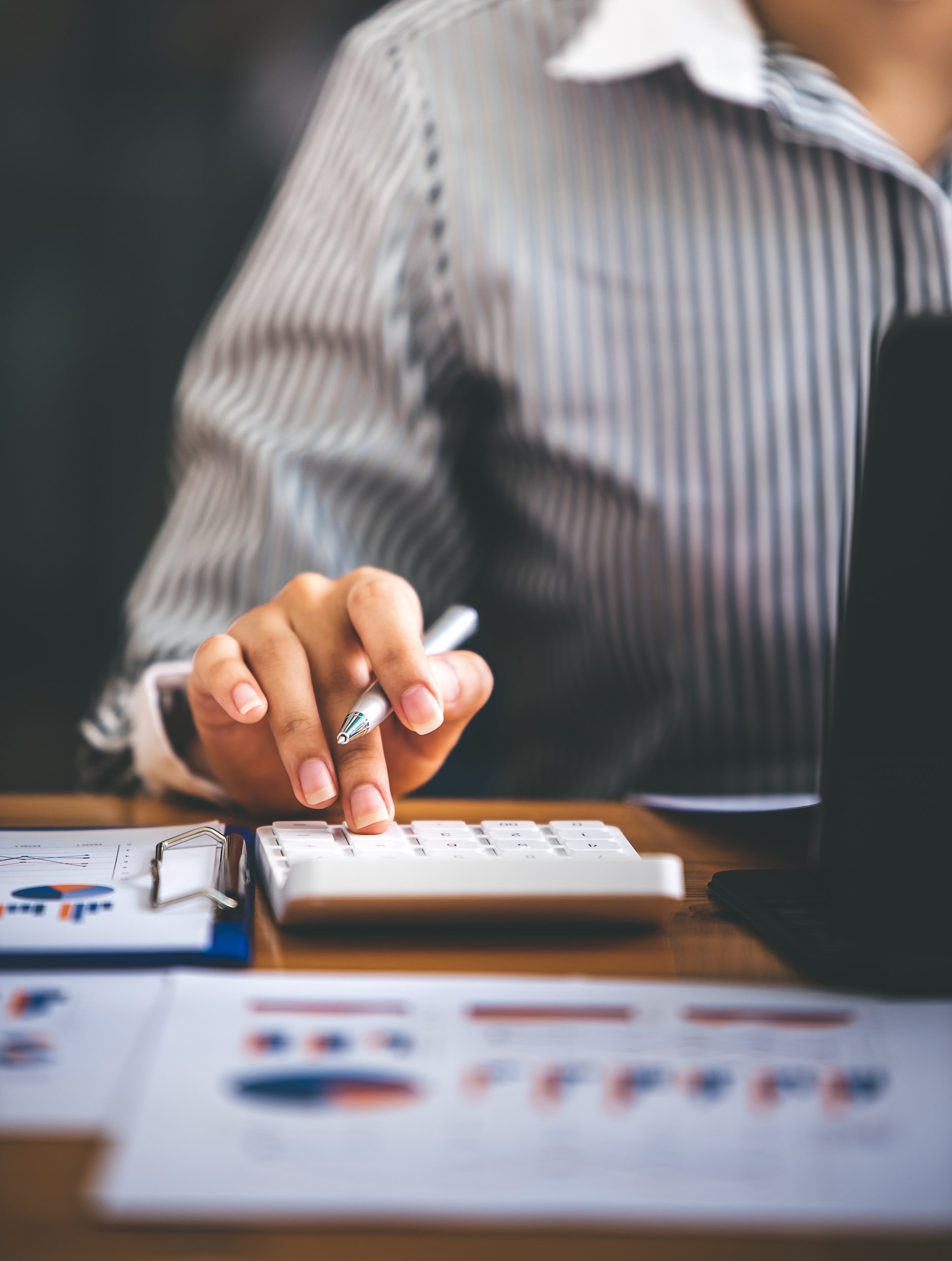 Comptable utilisant une calculatrice pour une analyse financière, page services du site Fiducia Management à Luxembourg